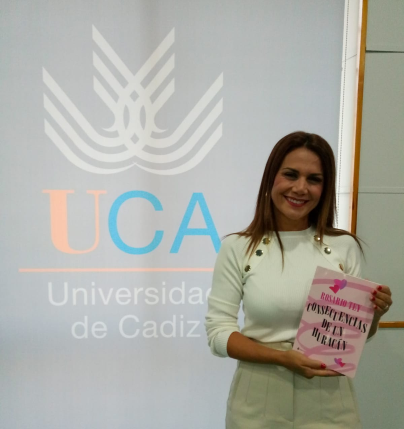 Rosario Tey, con un ejemplar de su nueva novela, "Consecuencias de un Huracán", en la biblioteca de la UCA.